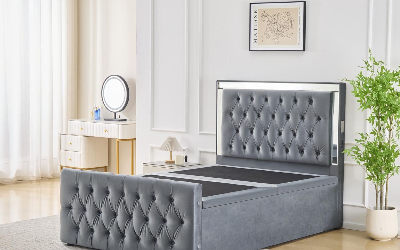 A bedroom set in the Exclusive Furniture showroom: a grey buttoned storage bed with matching bedsides and a dressing table